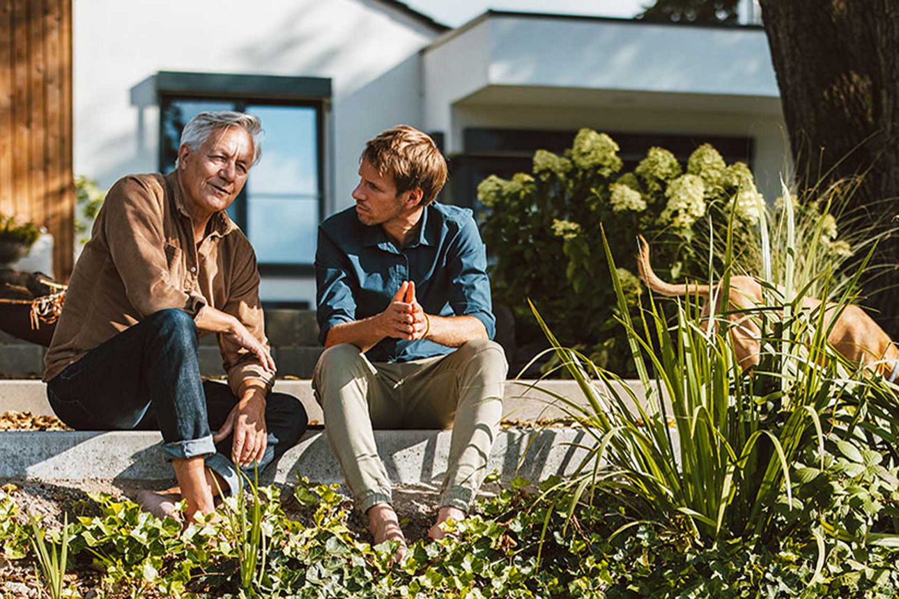 Ein Paar (Mann und Frau) schauen lächelnd zusammen auf ein Laptopbildschirm