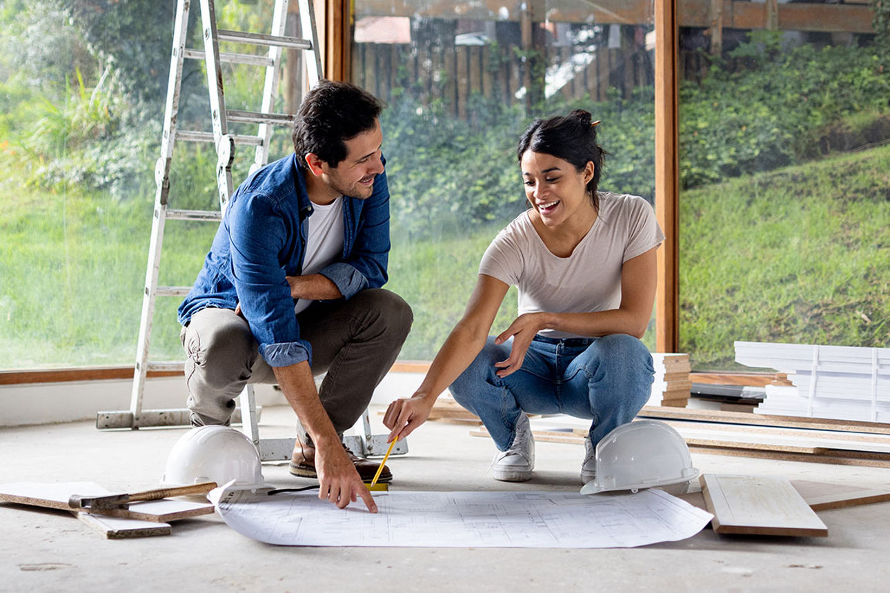 Mann und Frau besprechen auf einer Baustelle den Bauplan