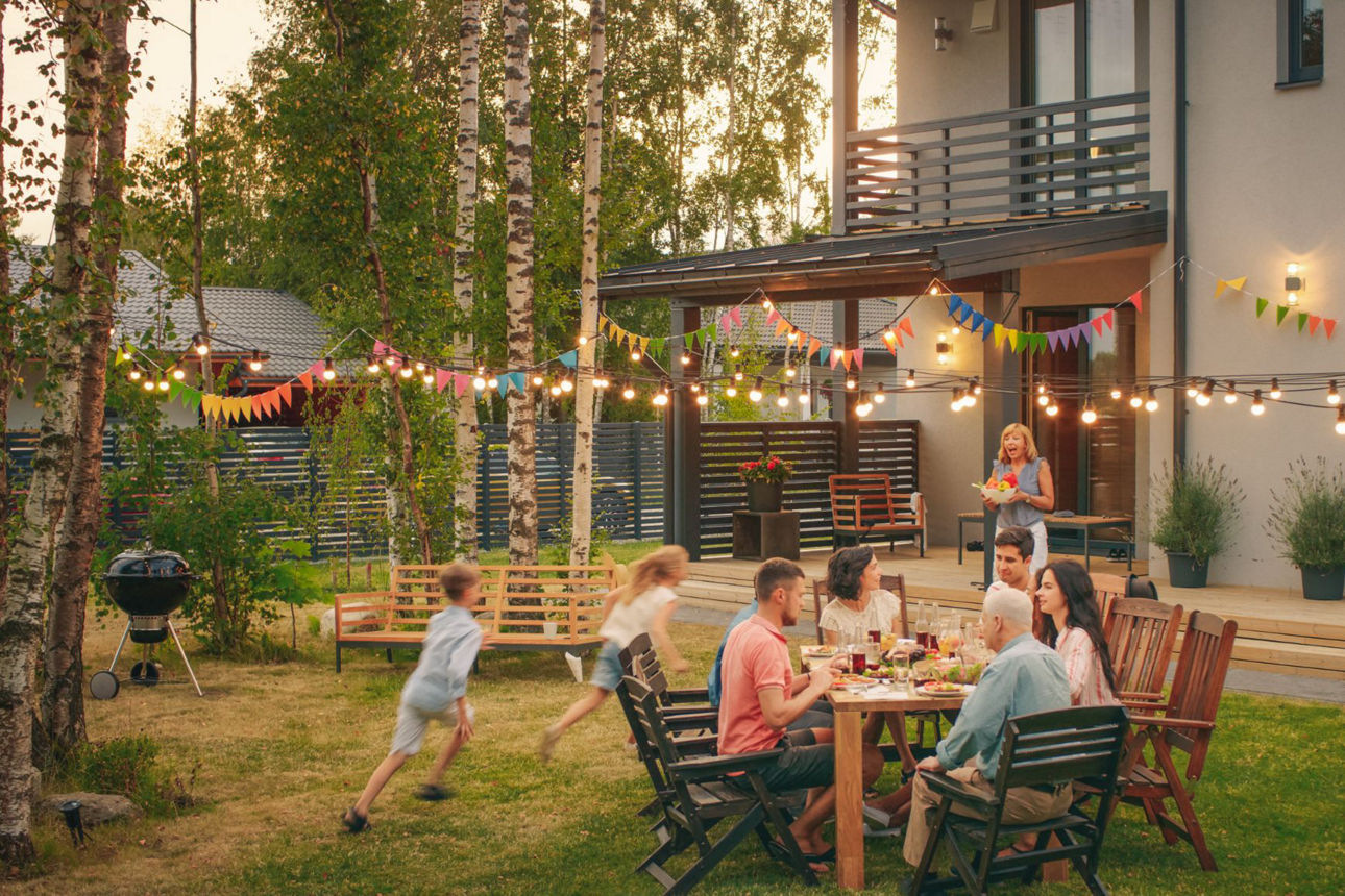  Eine Familie feiert in ihrem Garten eine ausgelassene Party mit Freunden