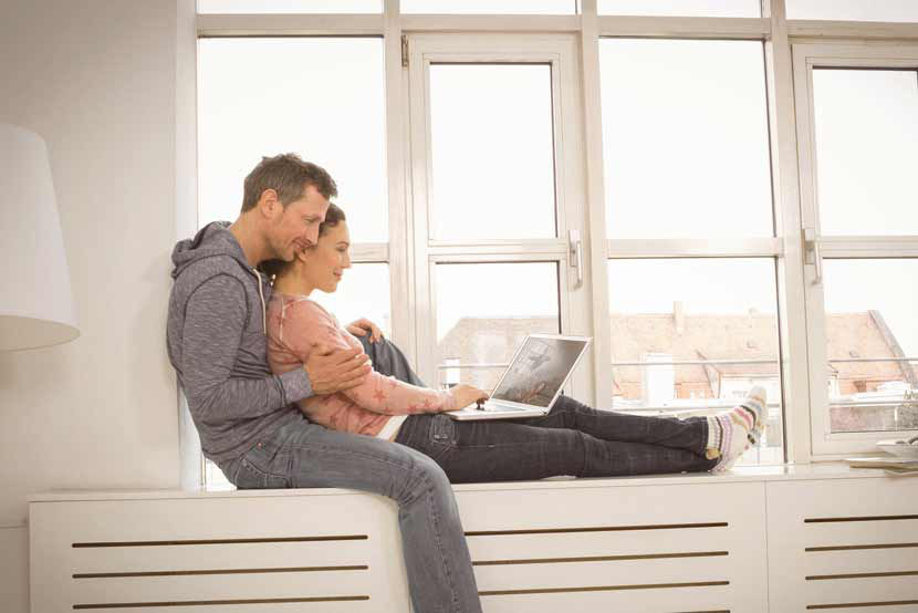 Relaxtes Paar in seiner neuen Immobilie am Fenster