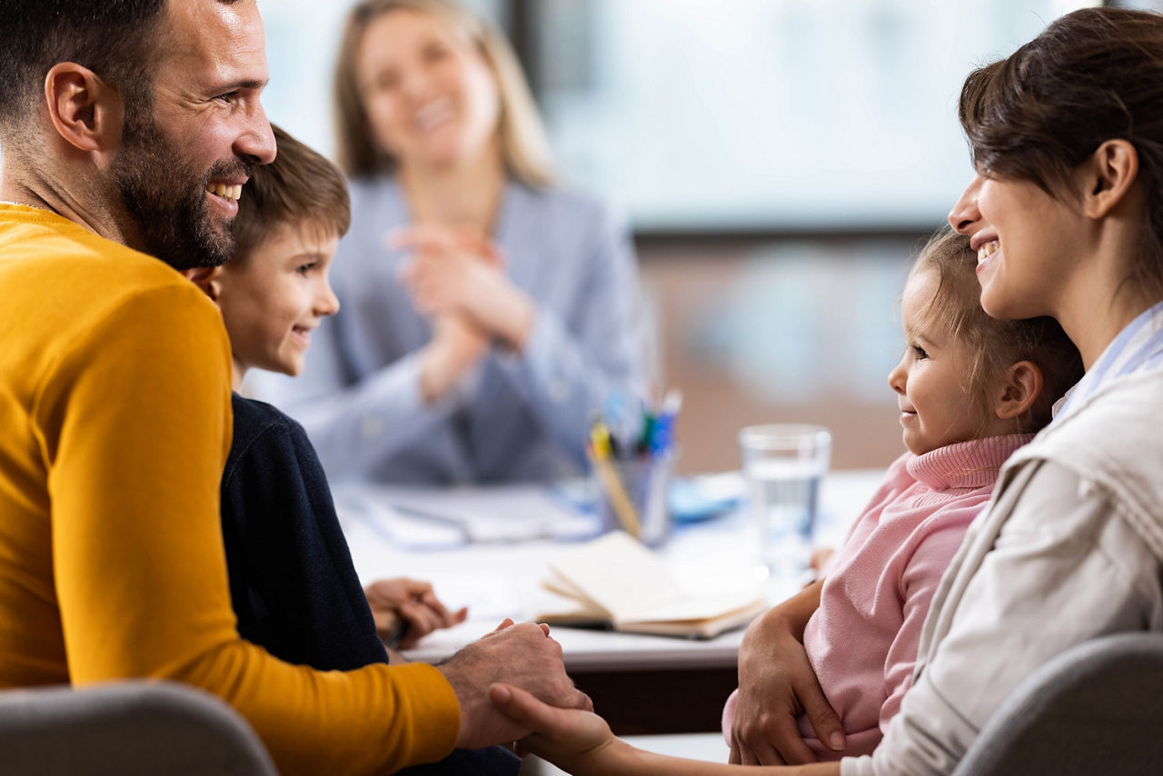 Eine junge Familie lässt sich zum aktuellen Immobilienmarkt in Deutschland bei ihrer Bank beraten.