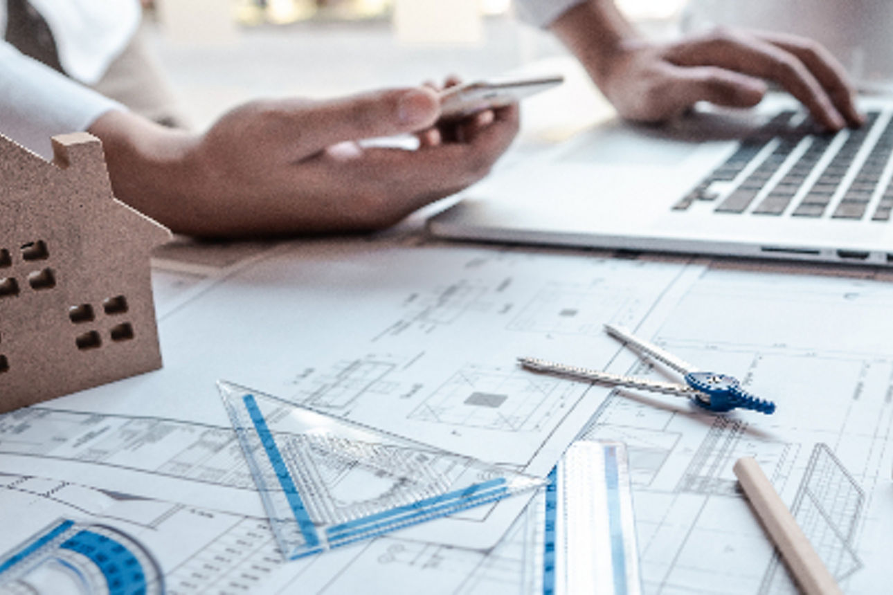 Projektplaner arbeiten mit Stift, Laptop und Messinstrumenten am Projekt