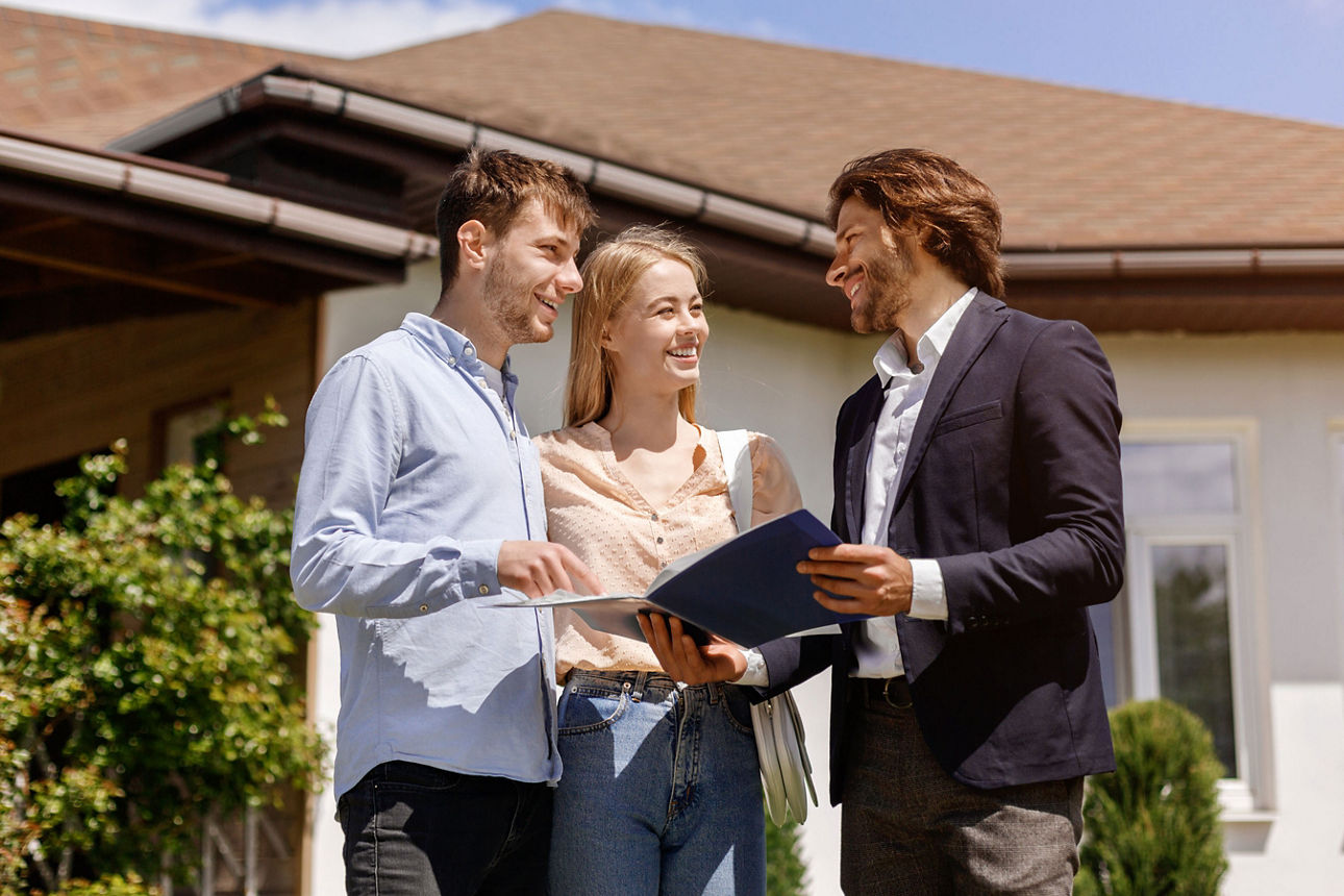 Immobilienmakler, der seinen Kunden im Hinterhof des Hauses den Miet- oder Kaufvertrag zeigt