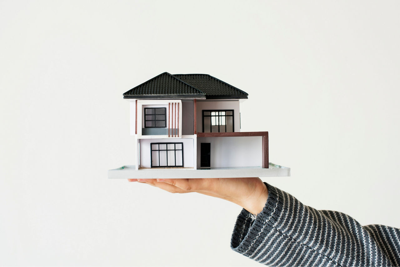 Ein Model eines Hauses wird auf der Hang gereicht