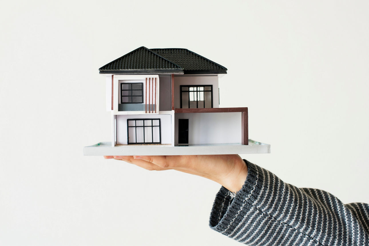 Ein Model eines Hauses wird auf der Hang gereicht