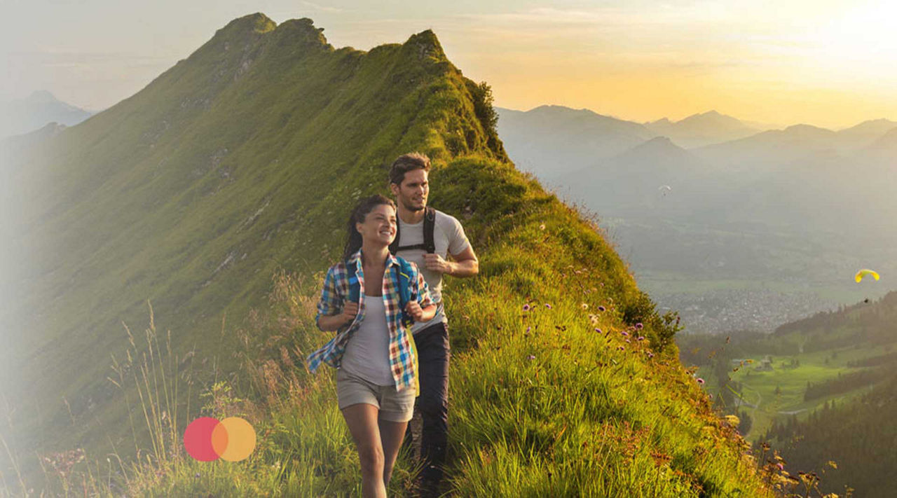 Mastercard® Identity Check Päarchen wandert über Bergkamm