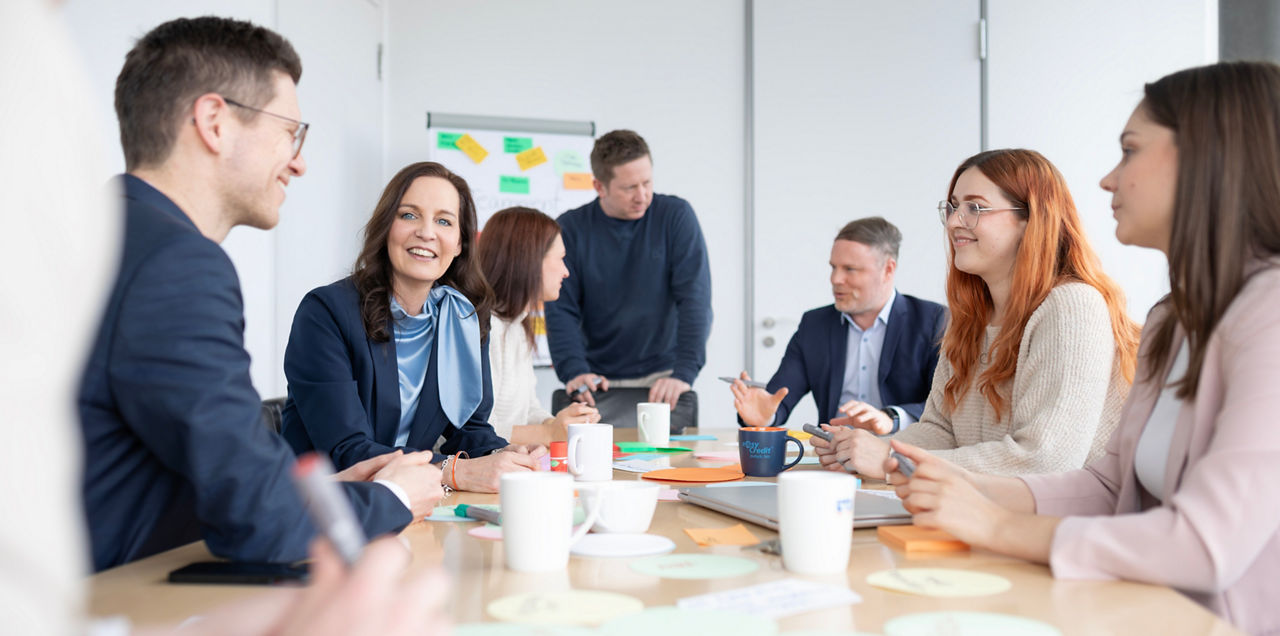 Besprechung in der Bank mit mehreren Leuten an einem Tisch
