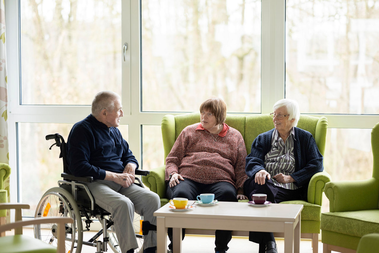Vater, Tochter und Mutter sitzen am Tisch und unterhalten sich