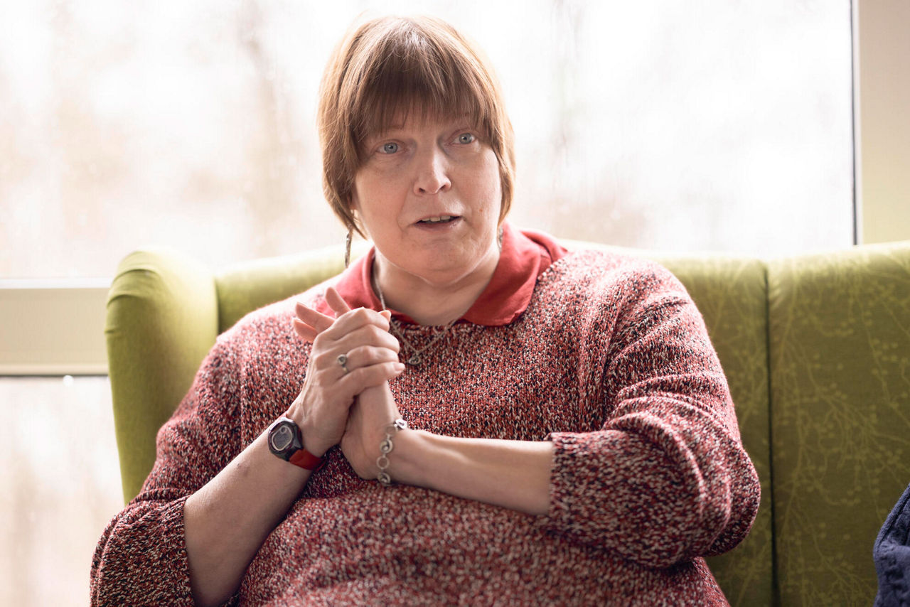 Eine Frau die auf einem gelben Sofa sitzt.