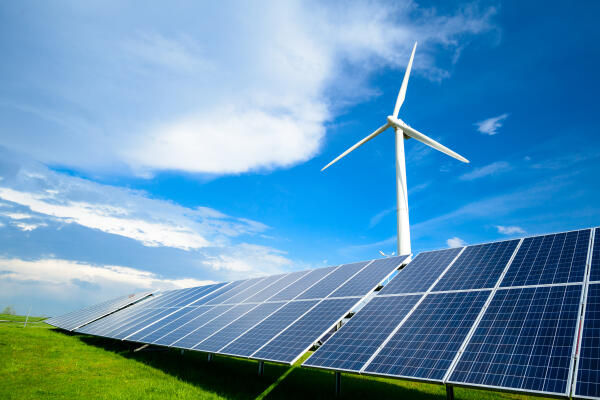 Sicht auf eine Solaranlage und ein Windkraftwerk in der Natur
