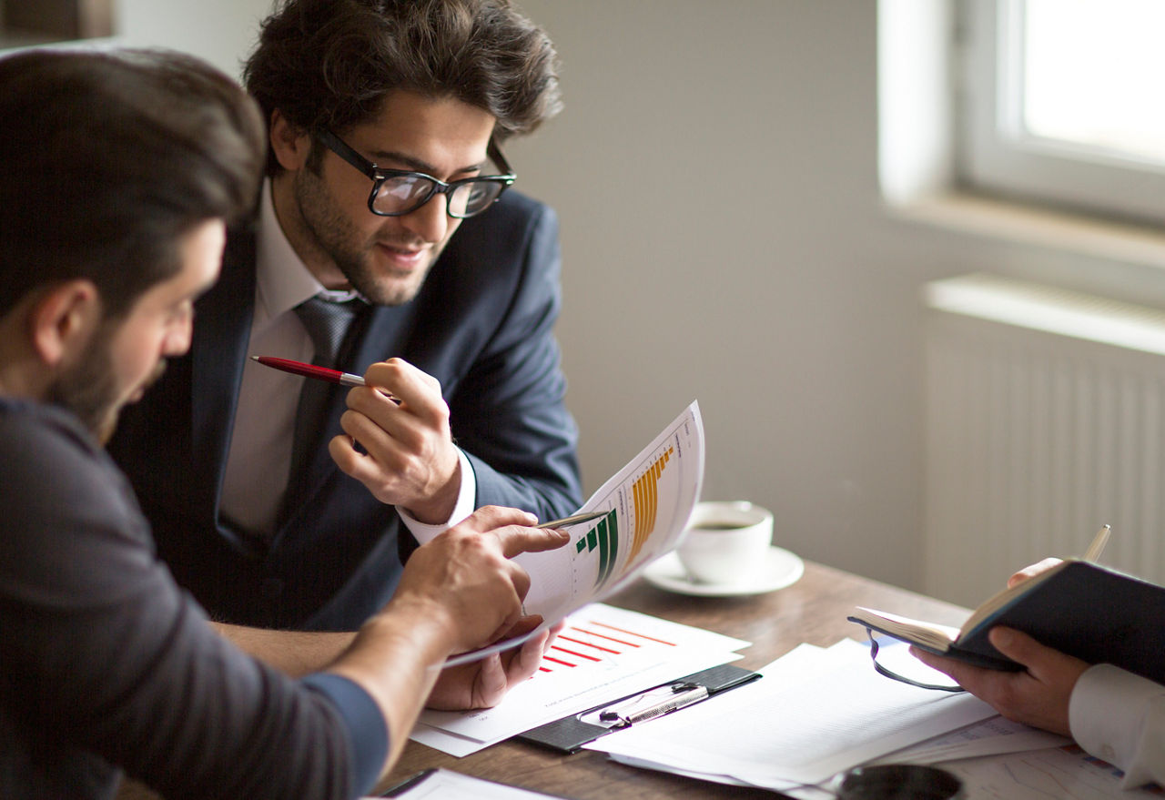 Business Analysten unterhalten sich darüber wie sie investieren wollen und denken über einen Kredit nach