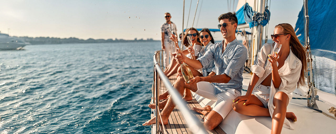 Eine Gruppe junger Menschen feiert auf einem Segeboot