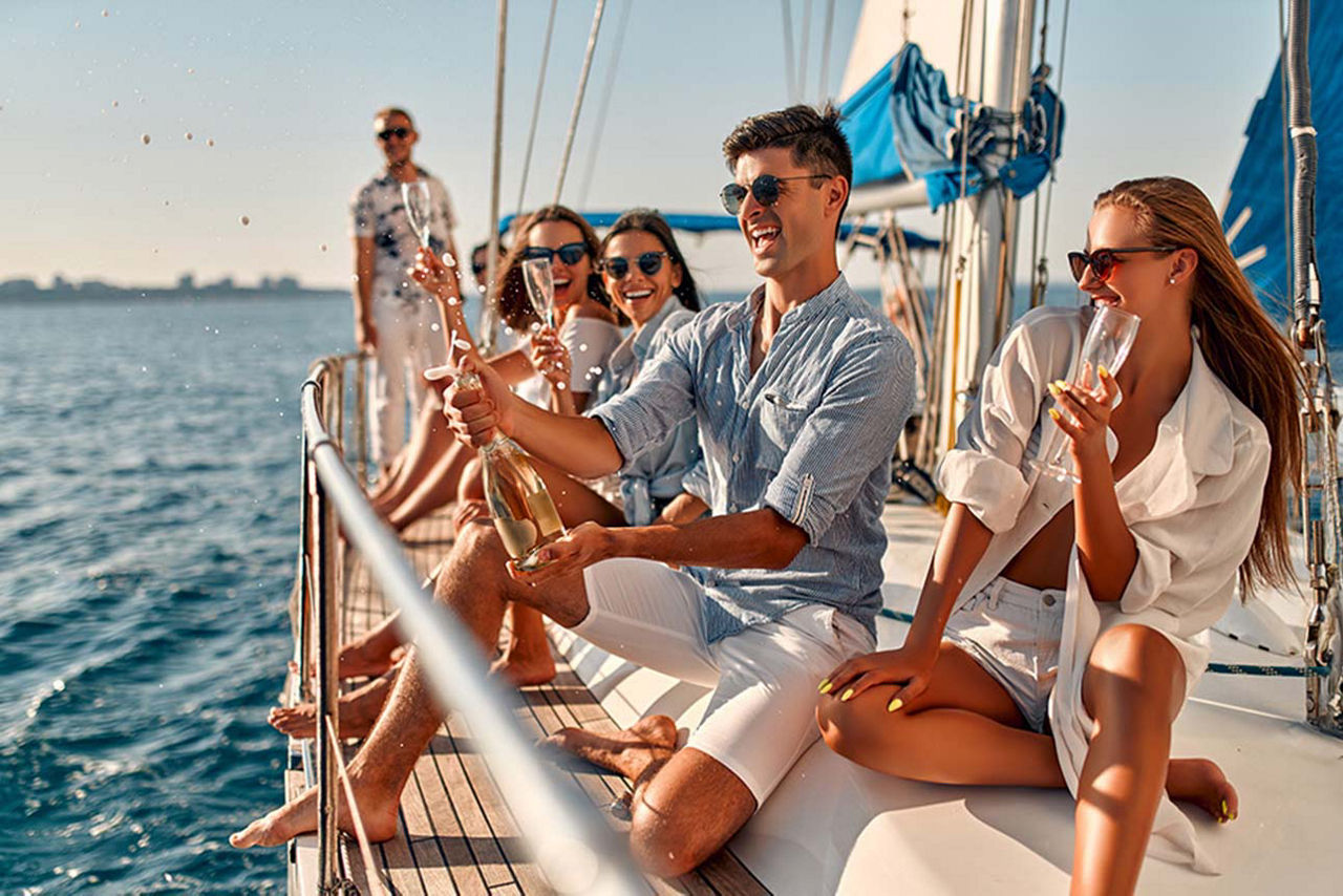 Eine Gruppe junger Menschen feiert auf einem Segeboot