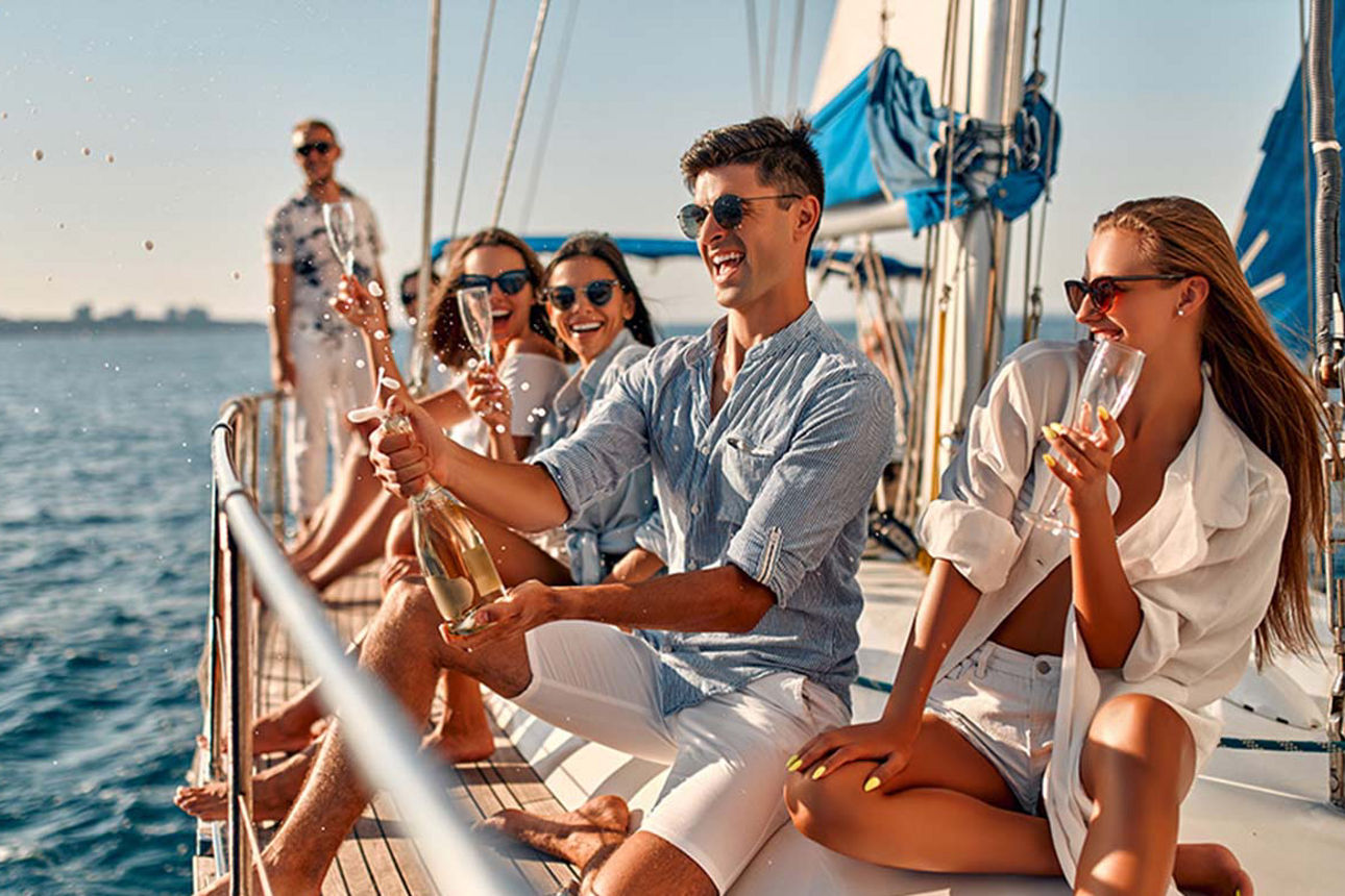 Eine Gruppe junger Menschen feiert auf einem Segeboot