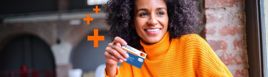 Junge Frau auf de straße schaut ins Handy und hat die girocard in der hAnd