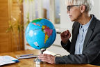 Frau im Büro schaut sich den Globus an