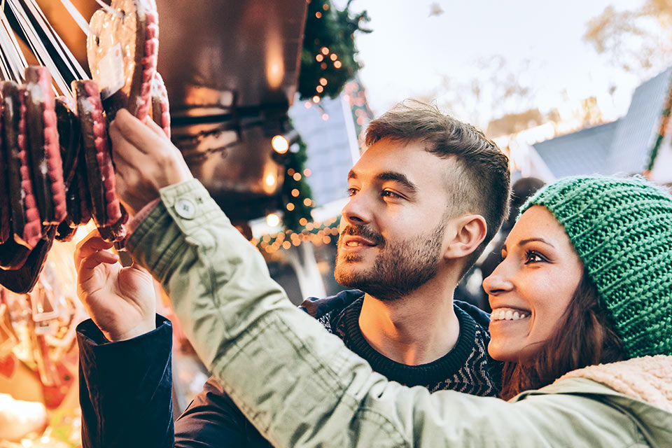 Ein junger Mann und eine junge Frau auf dem Weihnachtsmarkt