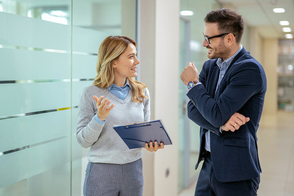 Zwei Menschen unterhalten sich in einem Büro