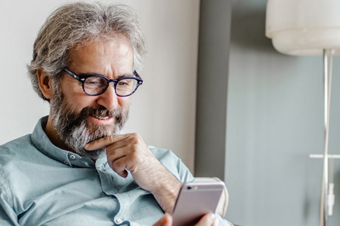 Ein Mann blickt auf sein Smartphone