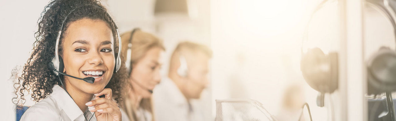 Eine Frau aus dem Callcenter lächtelt in die Kamera