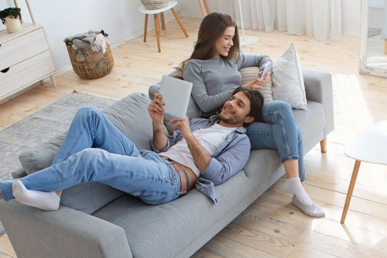 Zwei Personen sitzen auf dem Sofa und informieren sich zum Tagesgeld