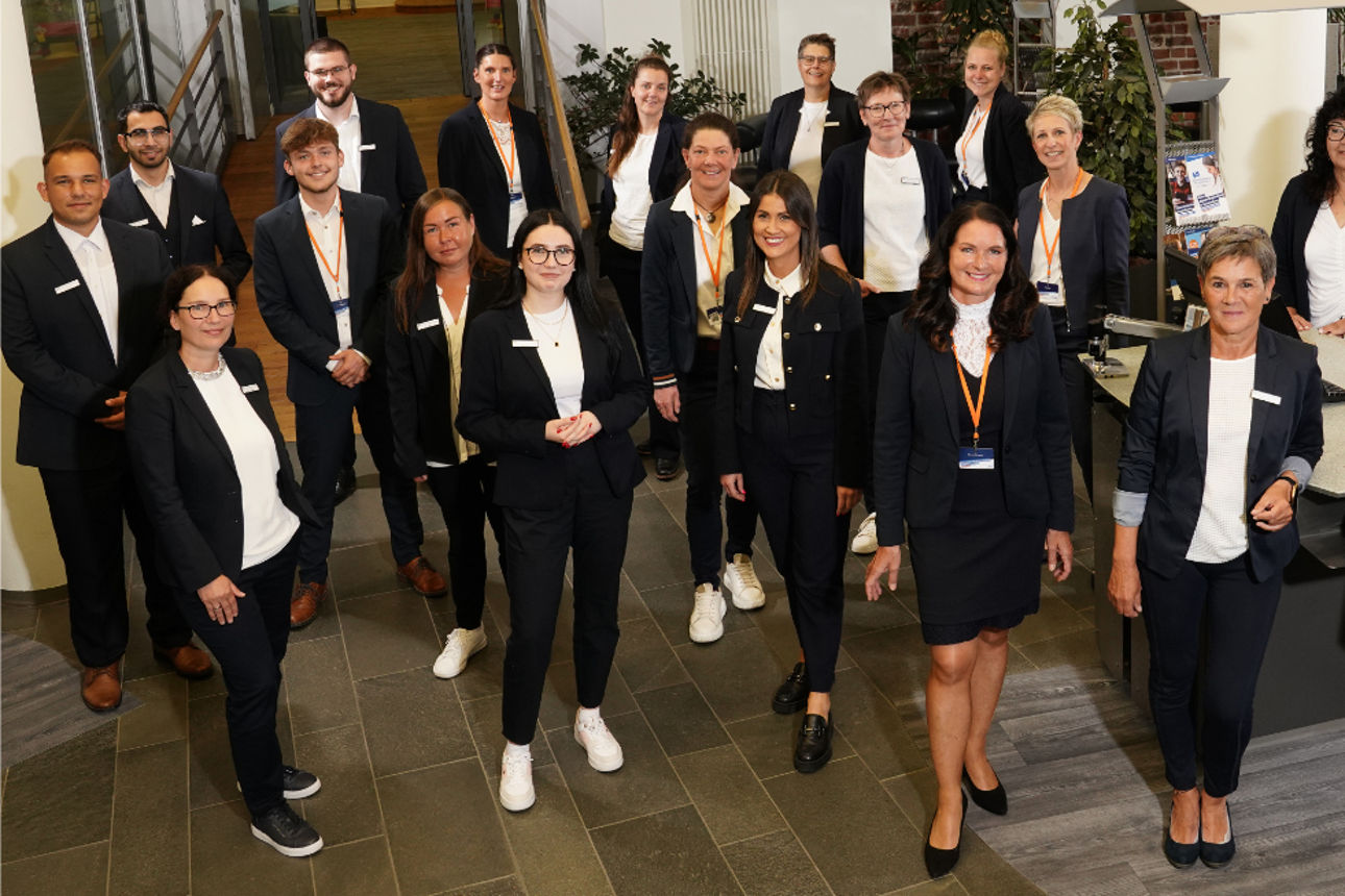 Gruppe von Beratern blickt lächelnd in die Kamera