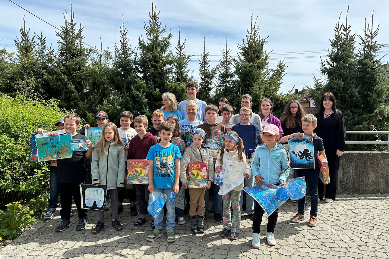 Schüler mit Ihren Bildern im Kalssenraum. 