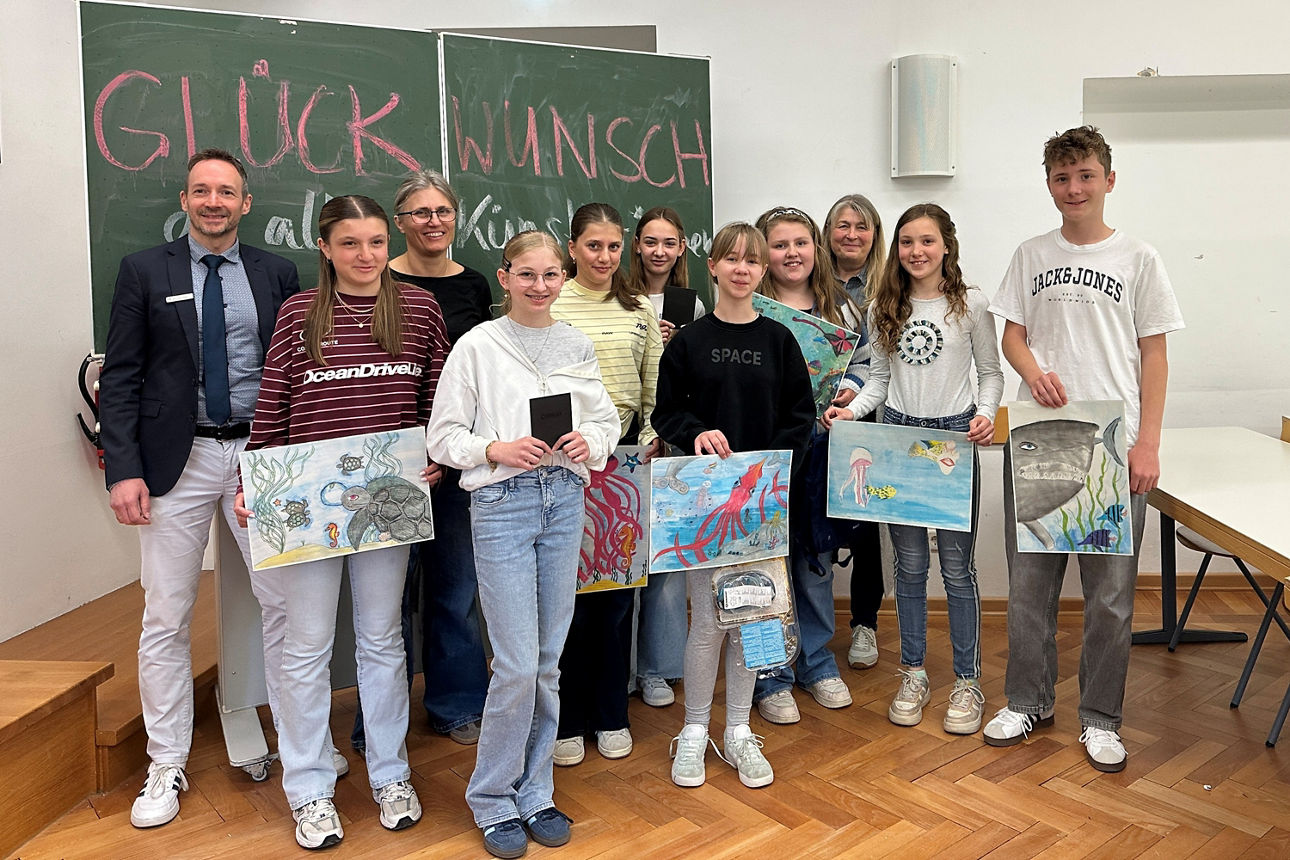 Schüler mit Ihren Bildern im Kalssenraum. 