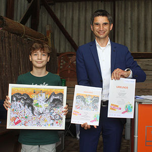Das Bild zeigt Aaron Geiß und André Peter, Teamleiter Marketing & E-Bankingbei der VR Bank Main-Kinzig-Büdingen. .Beide halten Gemälde in den Händen.