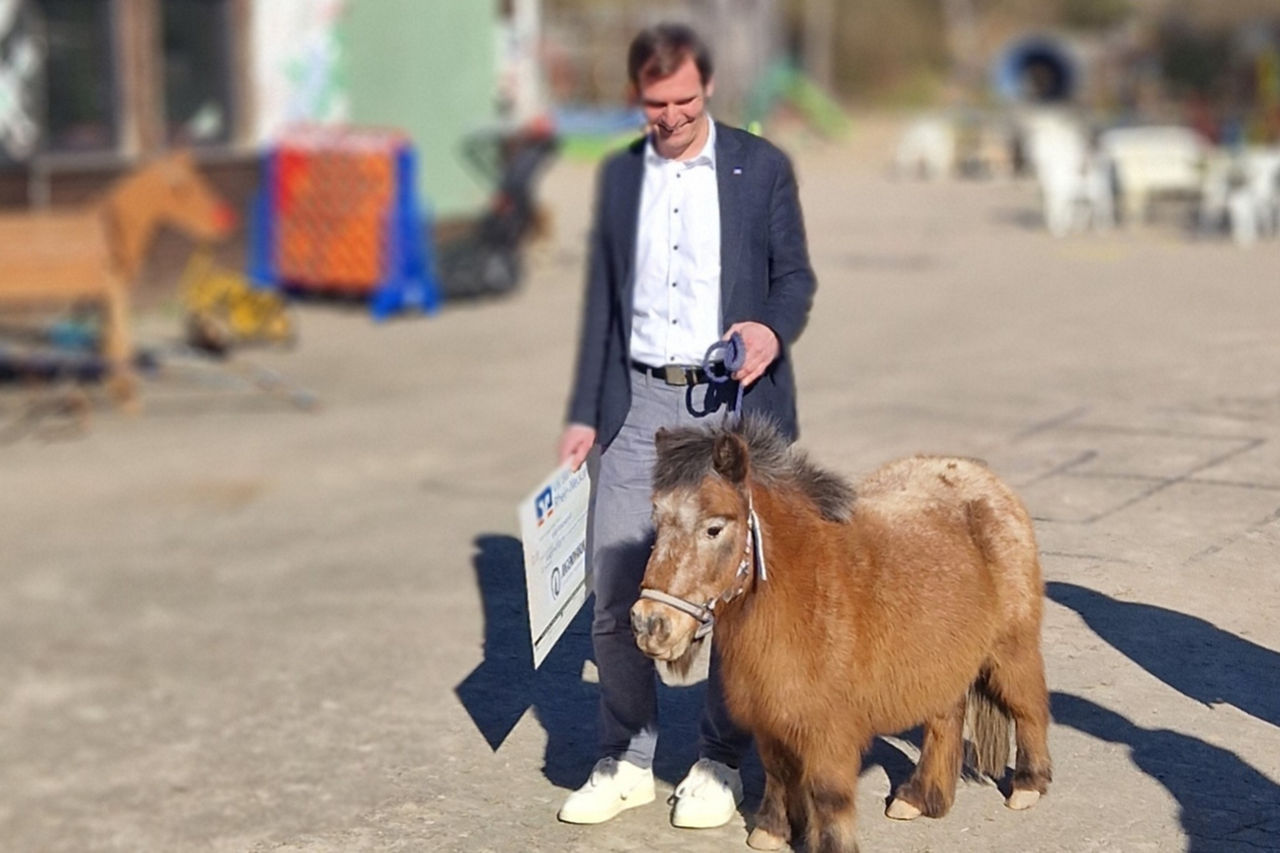 Jürgen Gärtner überreicht der Jugendfarm Ludwigshafen-Pfingstweide einen Spendenscheck über 4.000 Euro