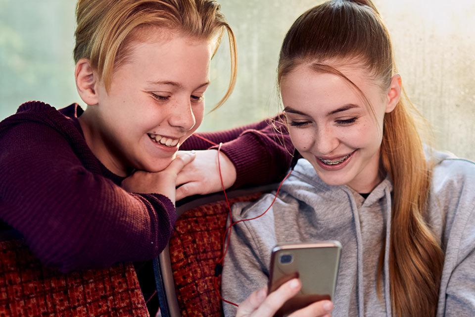 Zwei Jugendliche schauen in ein Handy