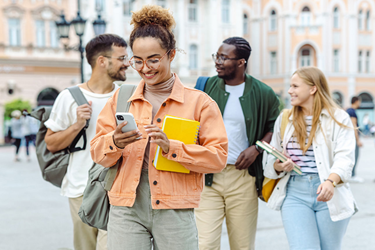 Schülerin geht nacht der Schule nach Hause und tippt auf ihrem Handy