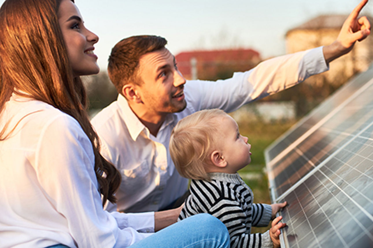 junge Familie schaut sich eine Solaranlage an