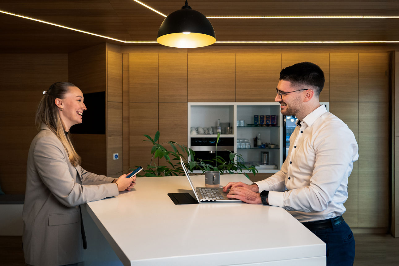 Eine junge Frau und ein junger Mann stehen an einem Tisch