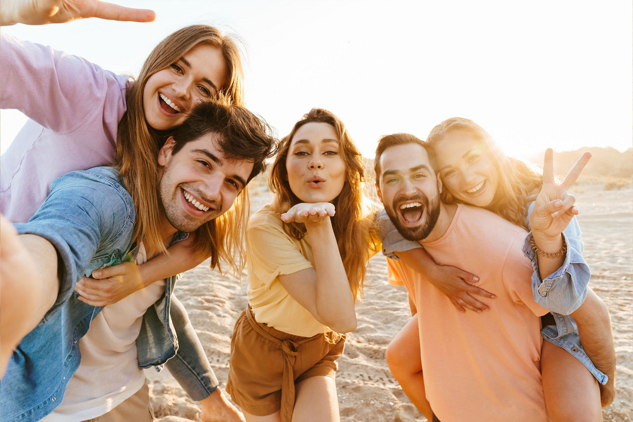 Selfie von jungen Menschen lächelnd beim Gehen am Strand