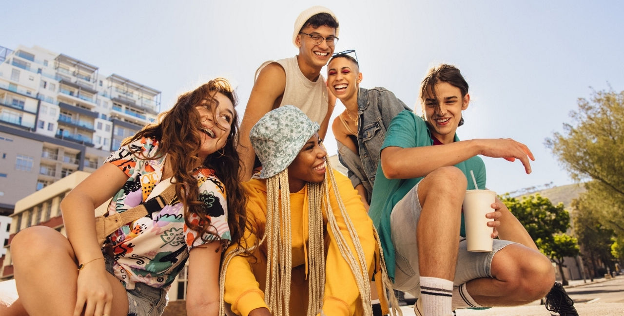 Gruppe von fünf jungen Menschen in lässigem Sommeroutfit.