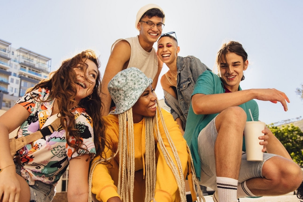 Gruppe von fünf jungen Menschen in lässigem Sommeroutfit.