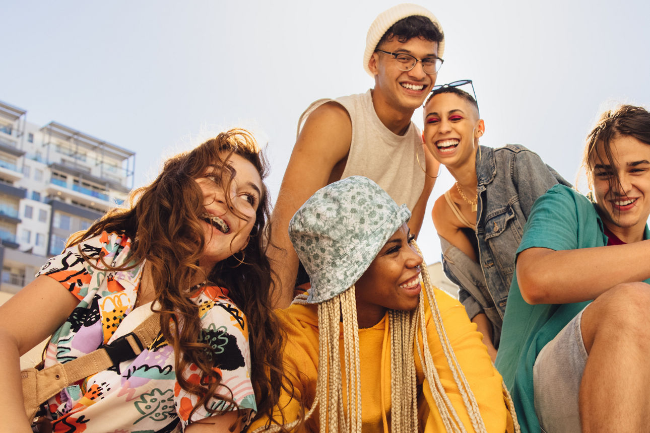 Gruppe von fünf jungen Menschen in lässigem Sommeroutfit.