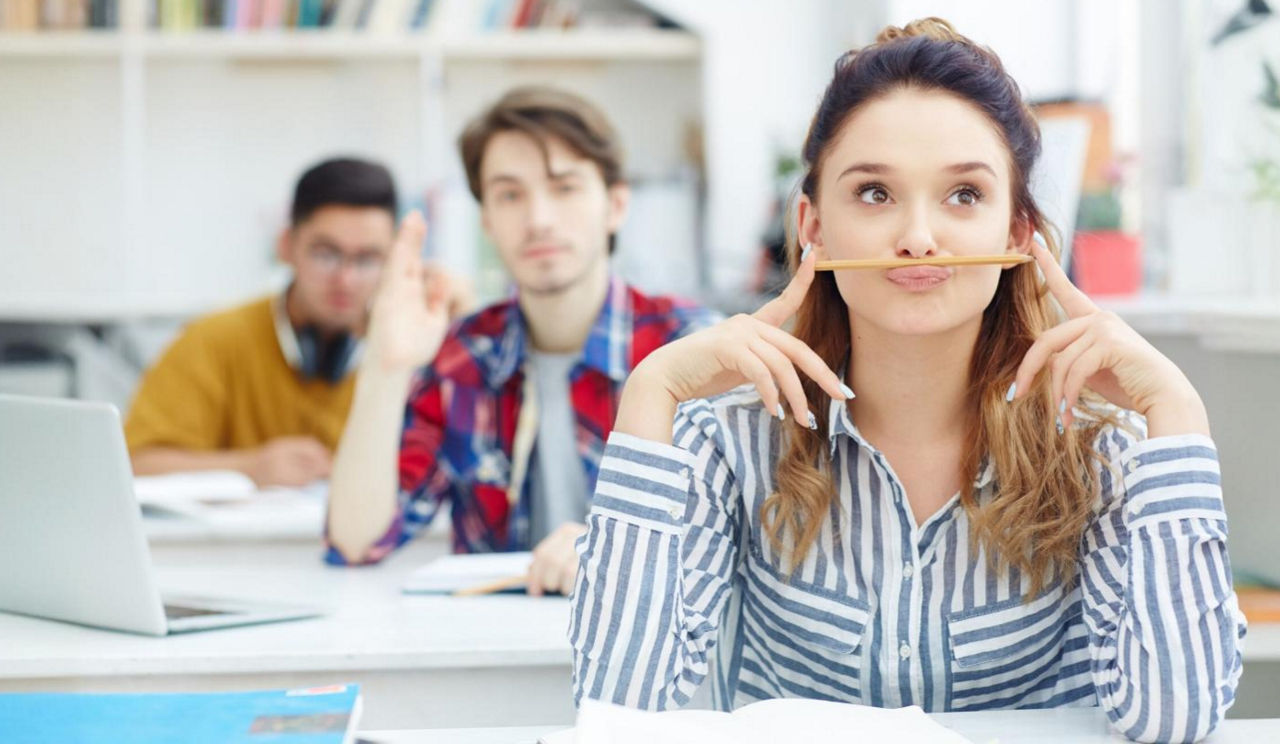 Die eigenen Finanzen verwalten Bild von Jugendlichen, die in einem Klassenzimmer sitzen und dem Unterricht folgen.