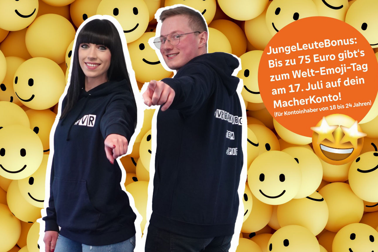 Zwei junge Menschen vor einer Wand mit Smileys deuten auf den Betrachter