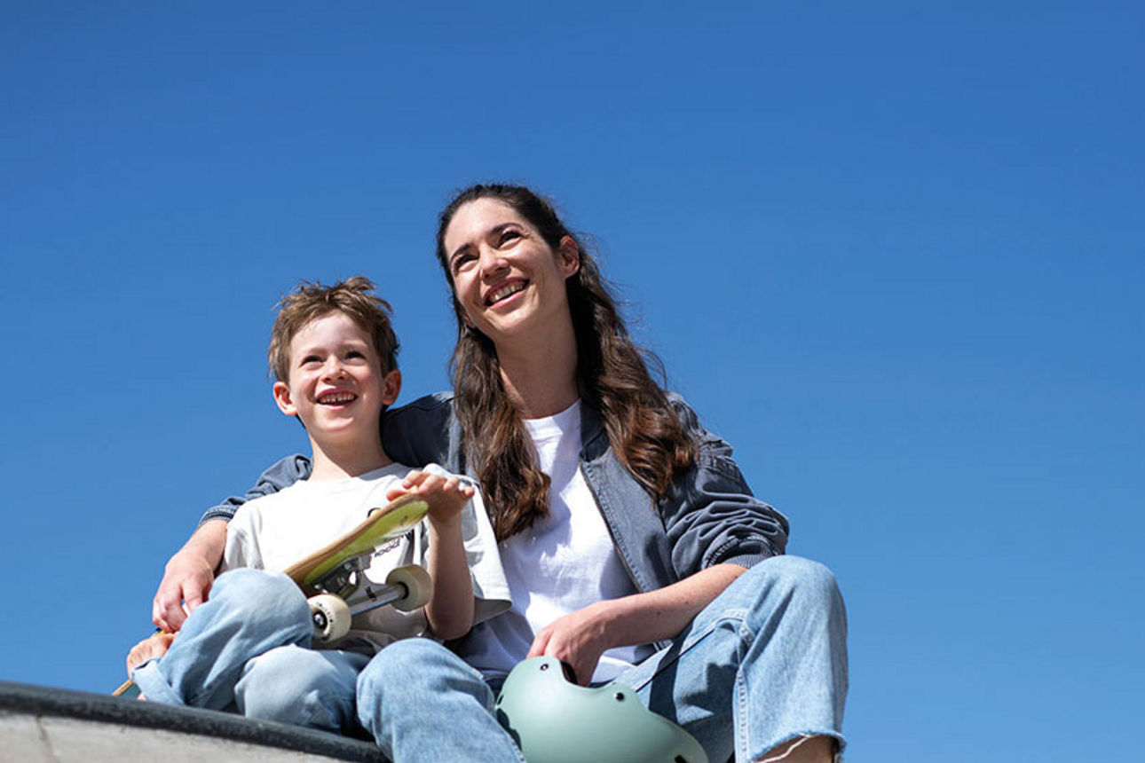 Junge und Mädchen sitzen an einer Skateboard-Rampe