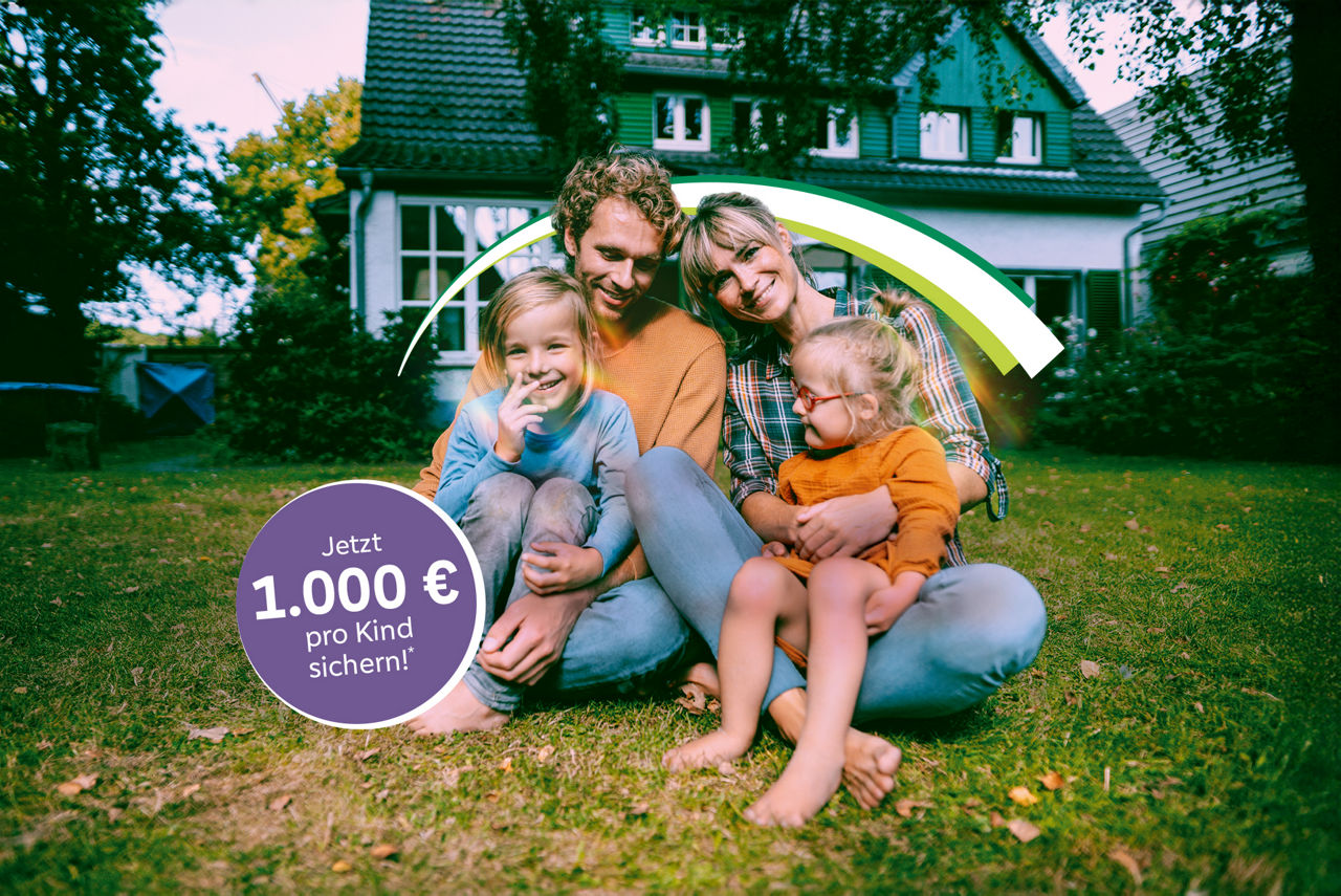 Glückliche Familie im Garten vor ihrem Eigenheim