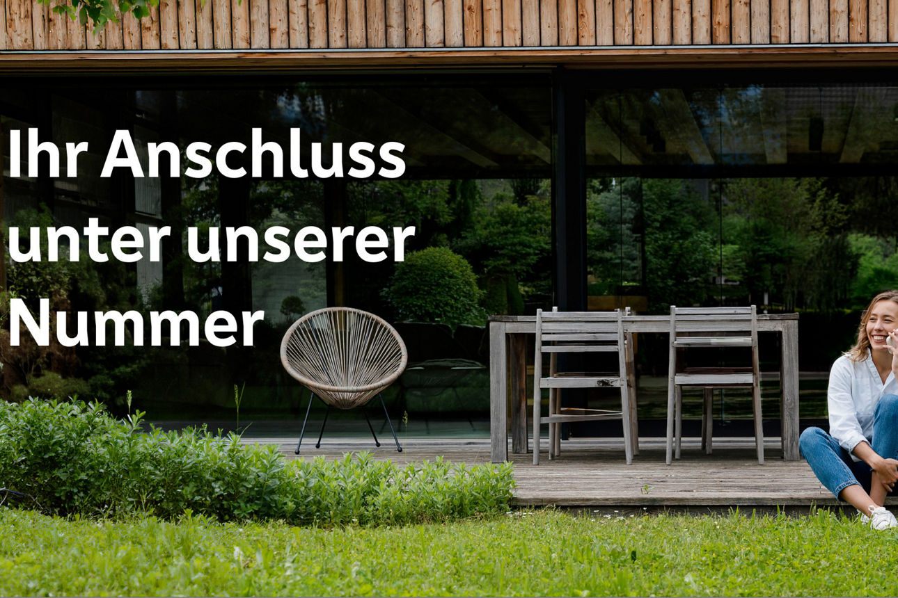 Frau sitzt entspannt auf ihrer Holzterrasse