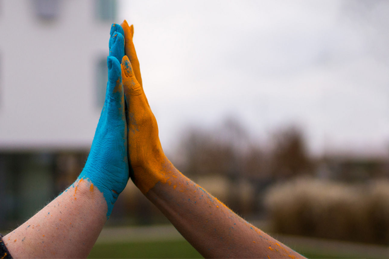 Zwei Hände vor dem Gebäude der Volksbank klatschen ineinander