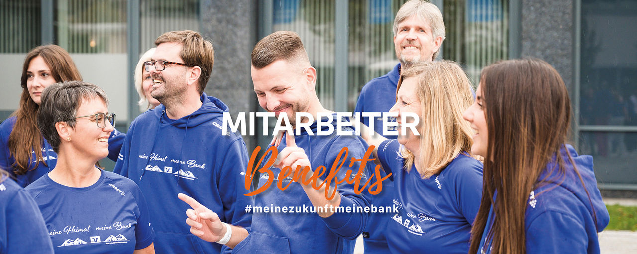Bild: Gruppe von Mitarbeitern in blauen Oberteilen freuen sich 