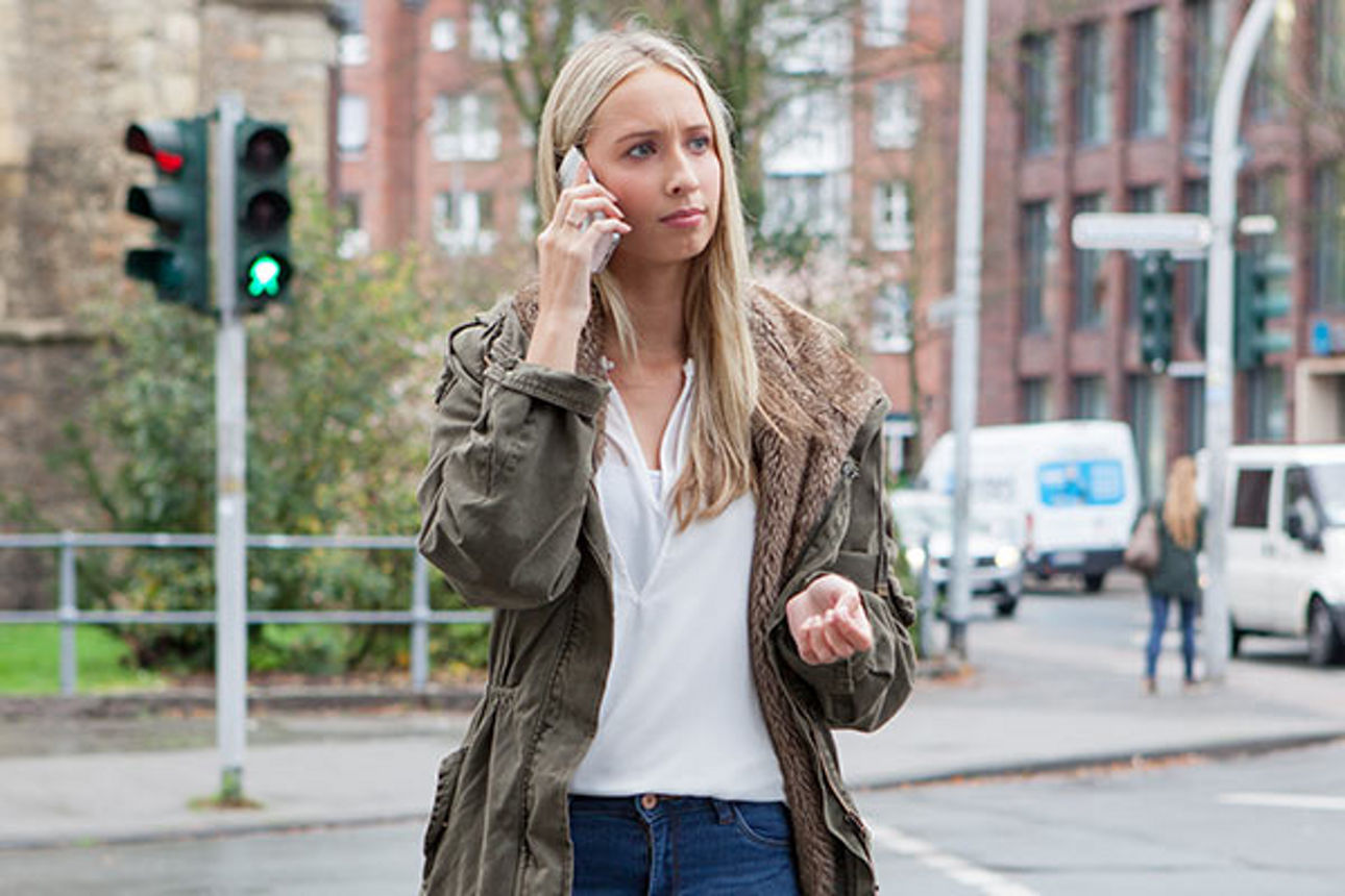 Junge Frau auf der Staße am Handy