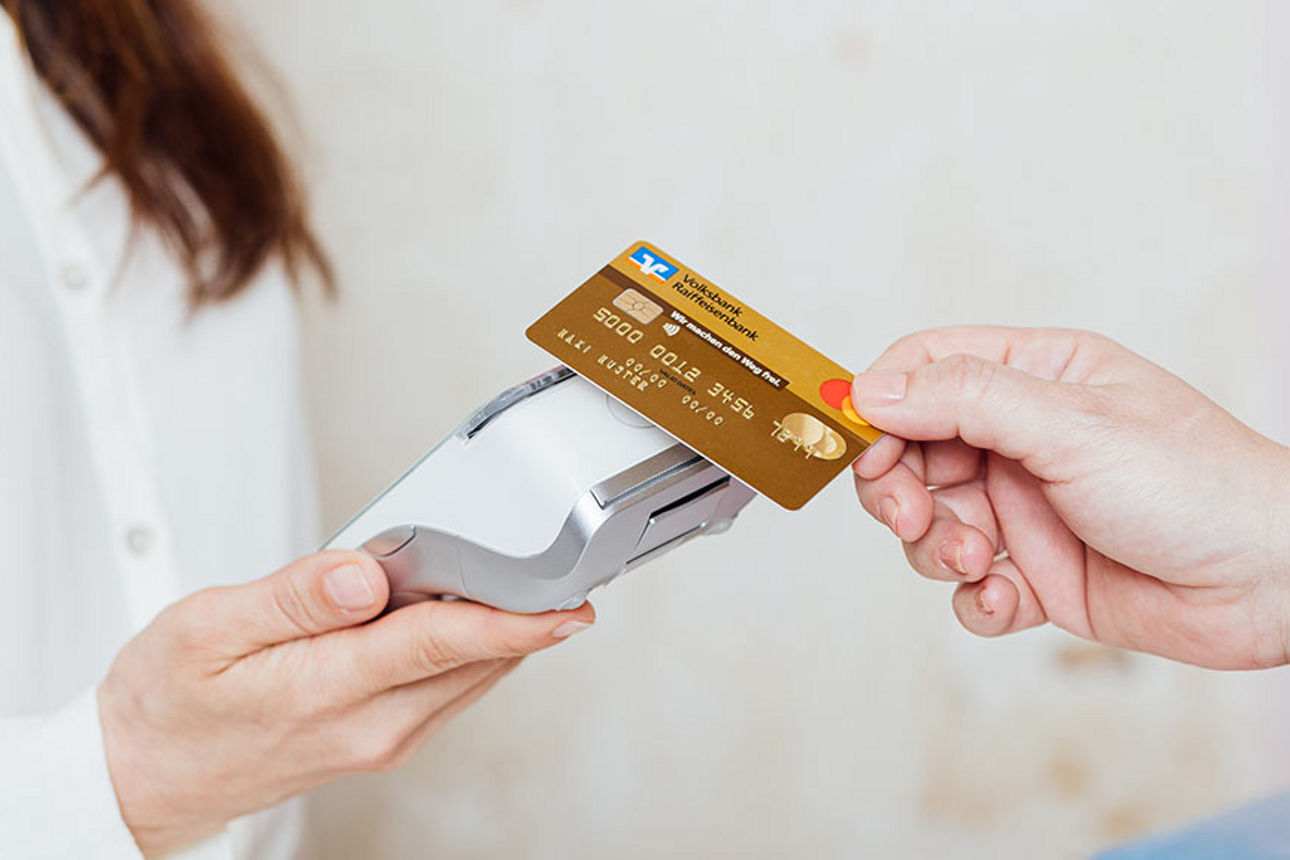 Mann zahlt mit Mastercard am Terminal