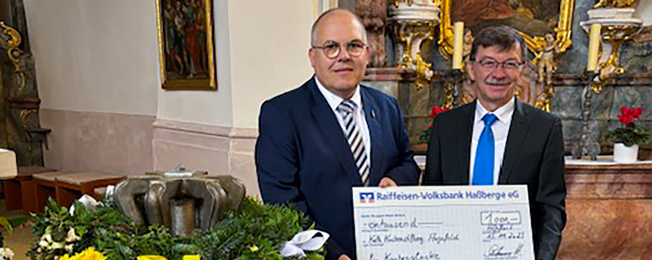 Herbert Schlemmer, Filialleiter in Haßfurt übergibt einen Spendenscheck an die Kirchenstiftung St. Kilian.