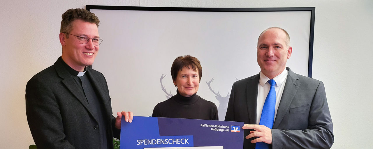 Alexander Rauschert, Kundenberater in Hofheim übergibt die Spende an die Kirchenstiftung Wettringen.