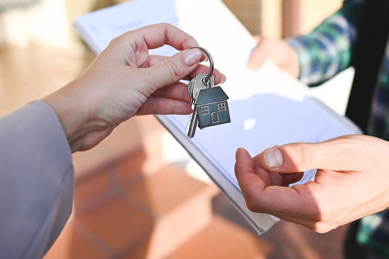 Eine Person übergibt einer anderen Person einen Haus-Schlüssel